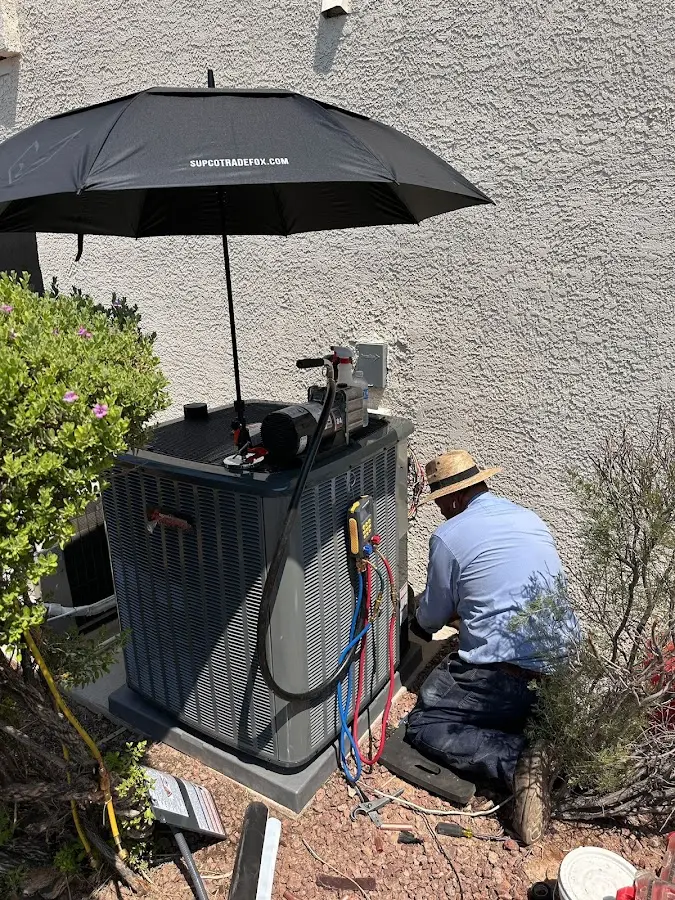 HVAC technician performing outdoor AC maintenance in Lansing